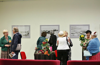 na zdjęciu w dalszej perspektywie Sonia Zengel odbierająca kwiaty oraz goście rozmawiający i oglądający obrazy