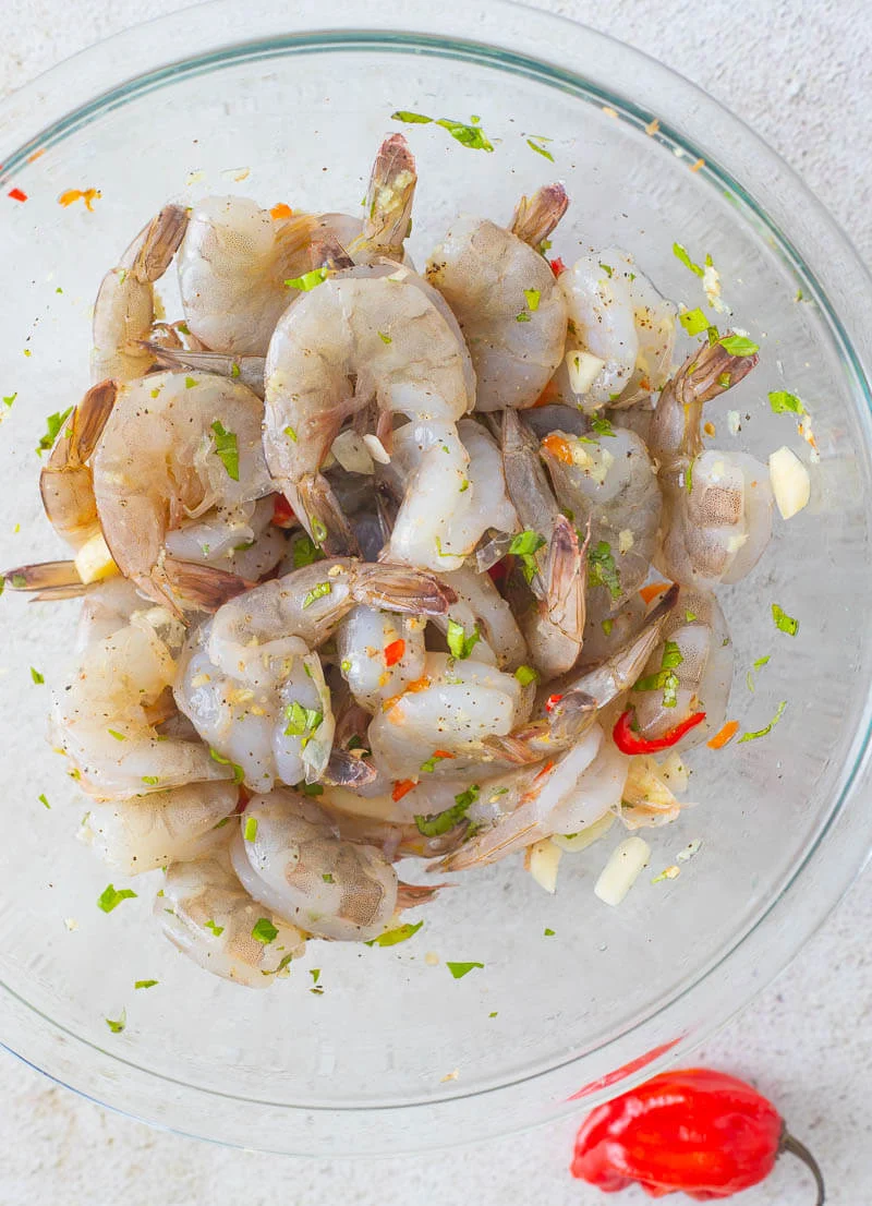 A bowl of shrimp, cleaned and seasoned up to be cooked.