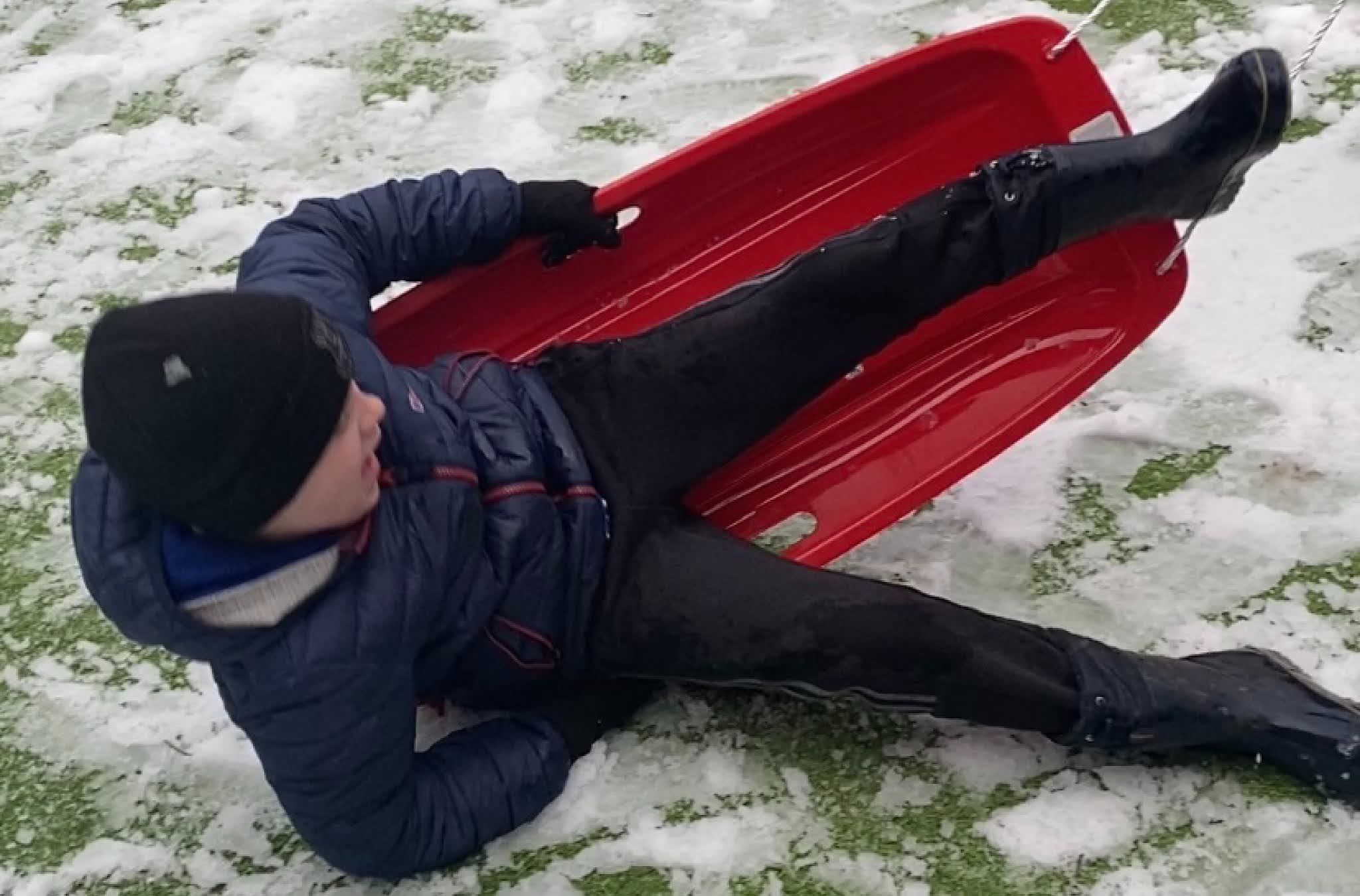 boy falling off a sledge