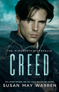 A young 20 year old male caucasian stares broodily on the cover of a book that reads "Creed" by author Susan May Warren