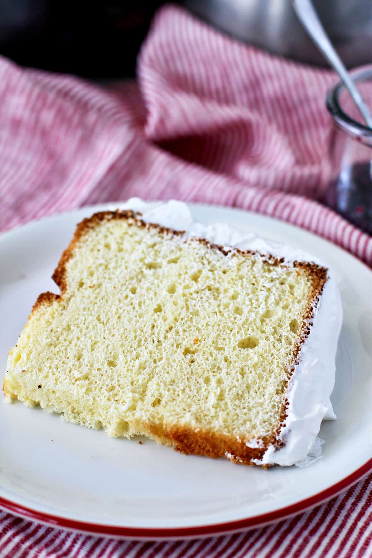 Olive Oil Chiffon Cake with whipped cream frosting on a plate.