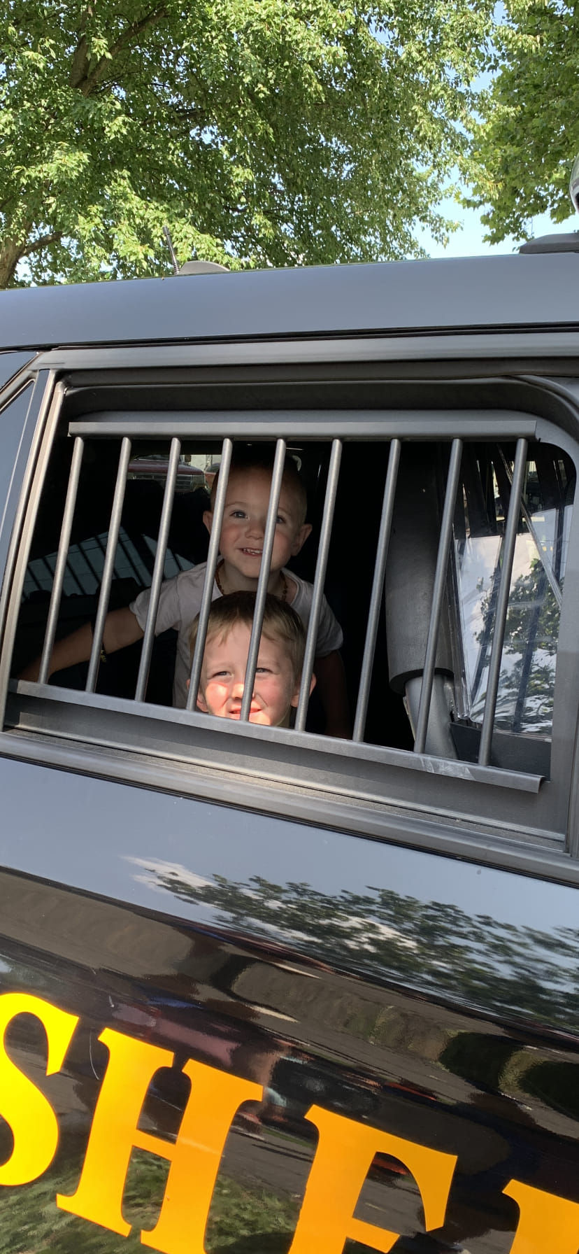 children in the back of sheriff car