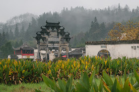 Arche Ming à trois niveaux et collines embrumées à Xidi