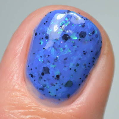 blue nail polish with color shifting flakies single finger close up swatch