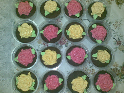 Ini contoh Chocolate cupcakes yang ada sekuntum mawar merah jambu atau 