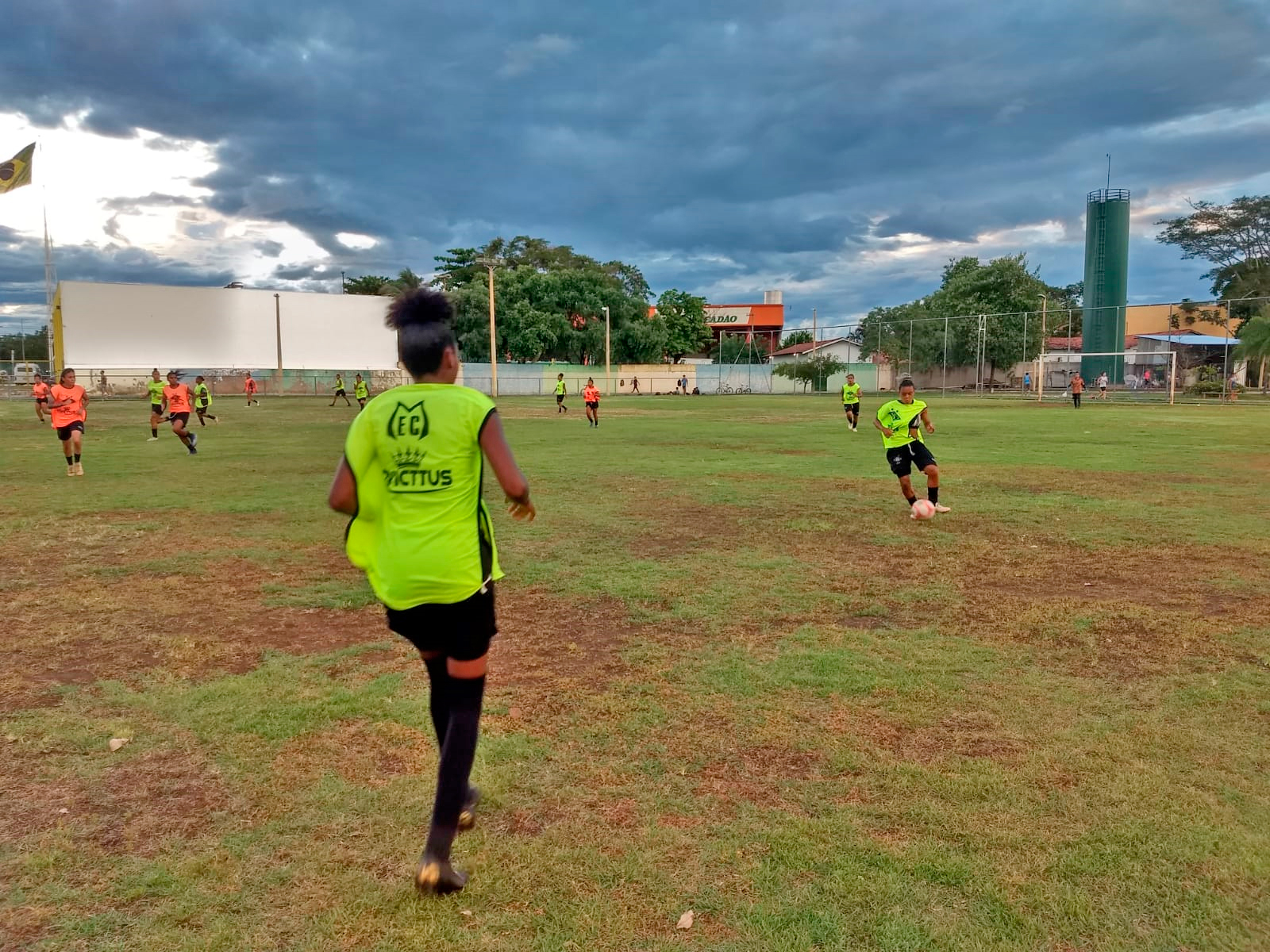 Meninas jogam futebol feminino no campo