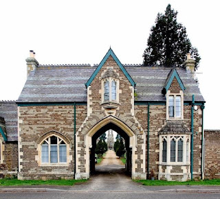 A large, carriage-arch, stone, gothic revival building