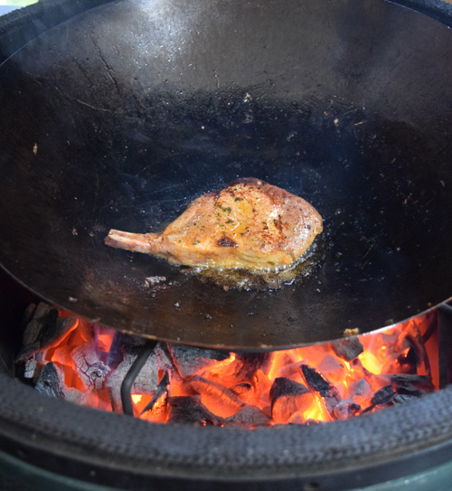 Shallow frying a Cheshire Pork chop in a wok on the Big Green Egg kamado grill