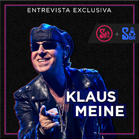 Na imagem, sobre um fundo preto, há uma foto de Klaus Meine, usando óculos escuros e apontando o dedo para a câmera. No topo, em letras de cor branca, está escrito: "Entrevista Exclusiva", em cima da foto do Klaus, está o nome dele "Klaus Meine" com um contorno azulado. Do lado direito da imagem, estão os logos da Scorpions News e do Scorpions Brazil.