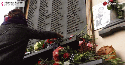 une personne qui dépose des fleurs en hommage aux victimes de la prise d’otage du théâtre Doubrovka