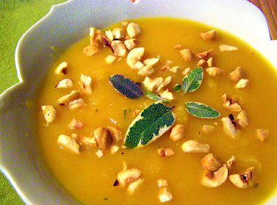 A bowl of smoother, more pureed soup garnished with nuts and sage