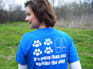 The back of the shirt has a pair of footprints next to 4 pawprints, and under it the words, It's more than just walking the dog!