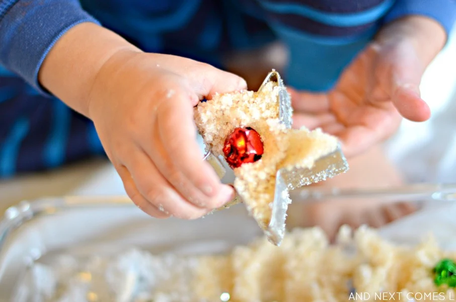 Playing with gold & silver epsom salts in a Christmas sensory bin from And Next Comes L