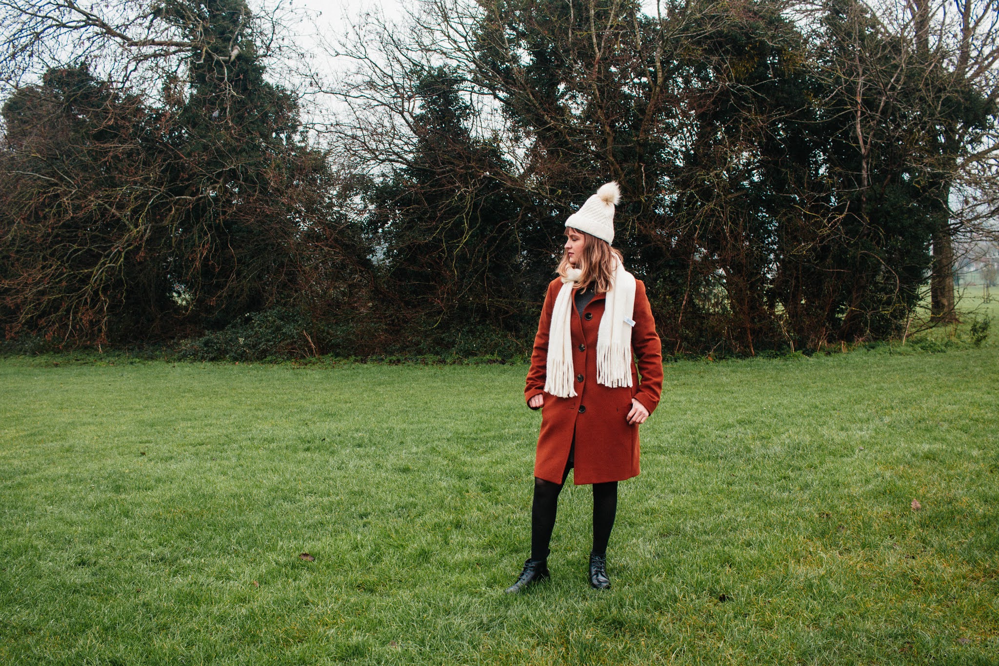 Girl dressed in coat, hat & scarf, in nature. January 2021 habits and goals blog post