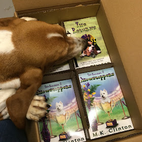 Basset looking at box of The Returns paperback books