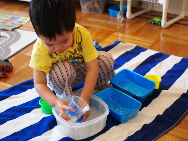 toddler playing with water beads