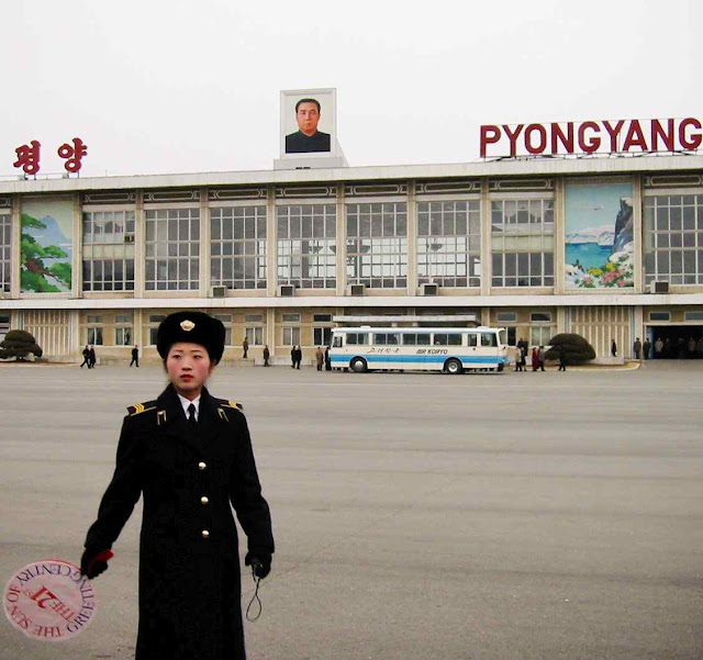 O controle começa no aeroporto, a guarda leva placa que diz 'O Sol do Século XXI', em homenagem a Kim Jong Il