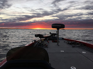 Photo of bass boat running toward the sunset.