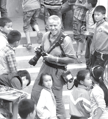 black and withe photograph of Bob Gomel with cameras