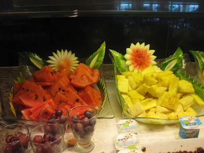 cut up pineapple , grapes, and watermelon displayed in nice bowls