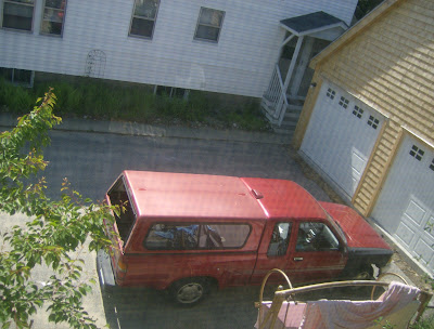 Old car parked in front of a garage shared with the house next door