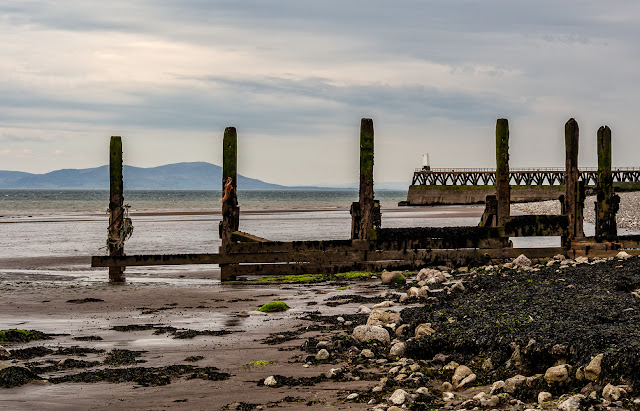 Photo of Maryport pier seen through an old groyne on the shore