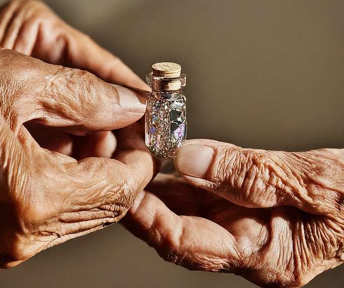 An old hand giving a precious vial to another hand to illustrate the meaning in a dream in Islam of depositing or entrusting something with someone