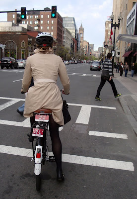 chic cyclist in a trench coat