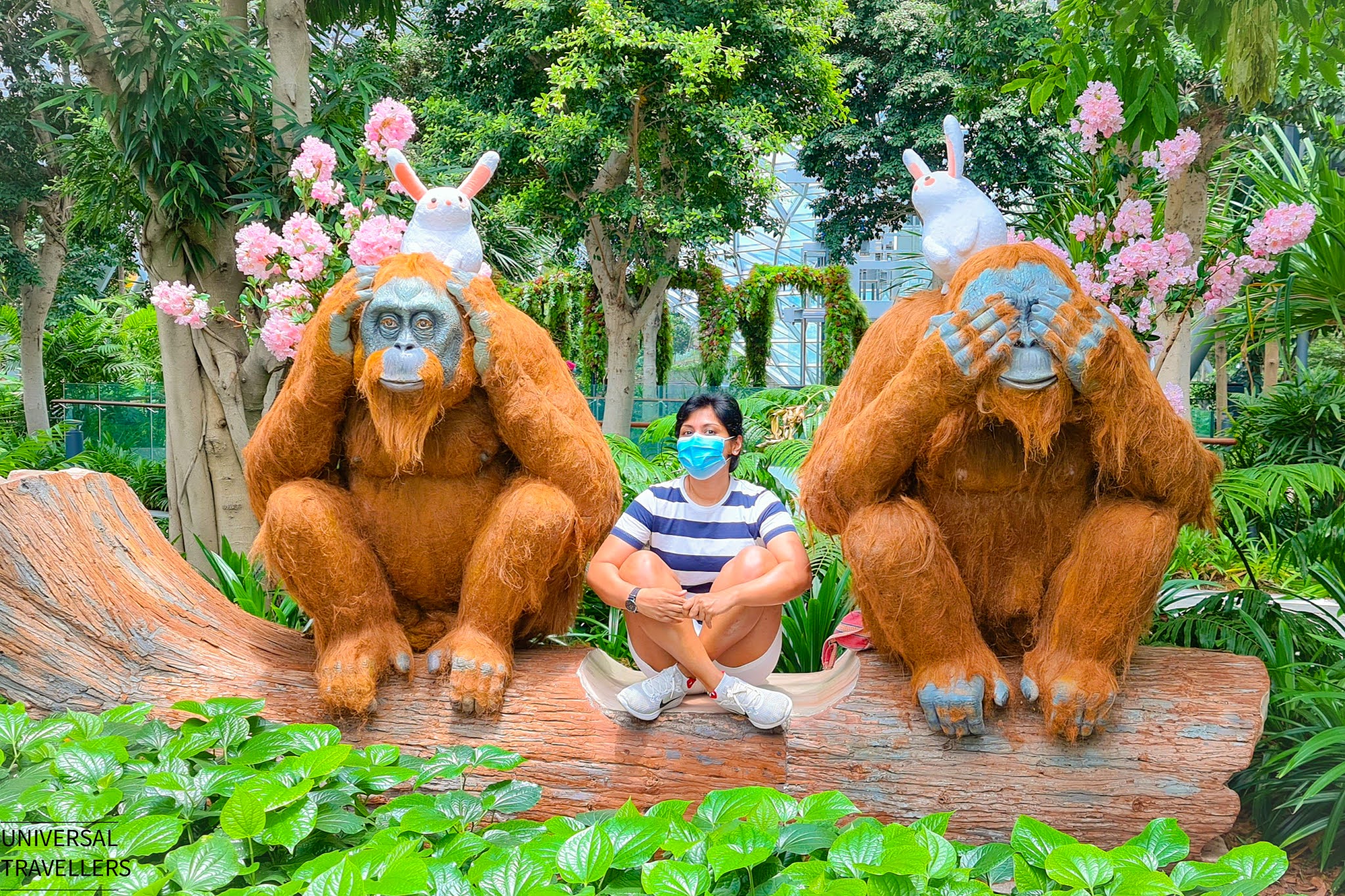 A girls is posing with two orangutans sculptures inside the Topiary Walk of Canopy Park, located at level 5 inside the Jewel Changi Airport