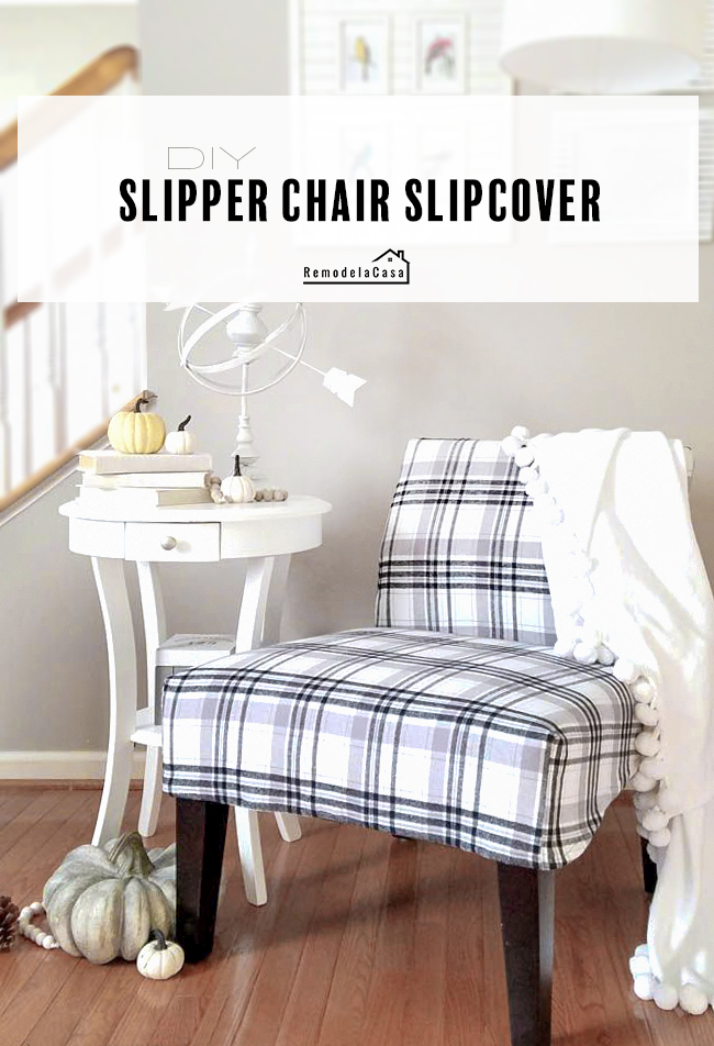 slipper chair with black and white plaid slipcover with pompom pillow and pumpkins around a white side table