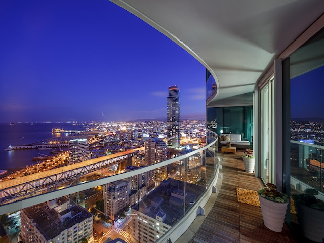 Picture of city lights and the bay at sunset as seen from the balcony of small duplex apartment