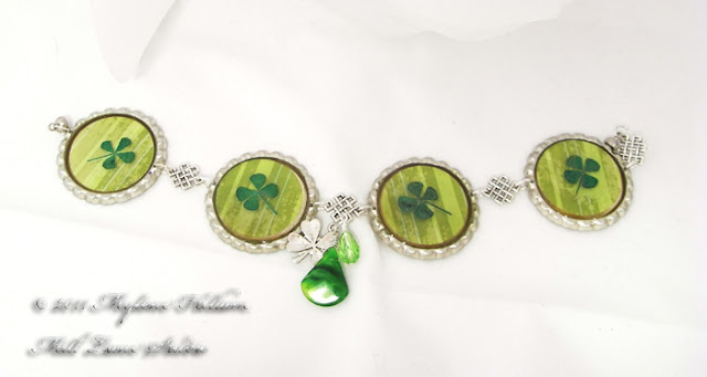 Bottle cap bracelet featuring green striped scrapbook paper with real dried 4 leaf clovers embedded in resin.