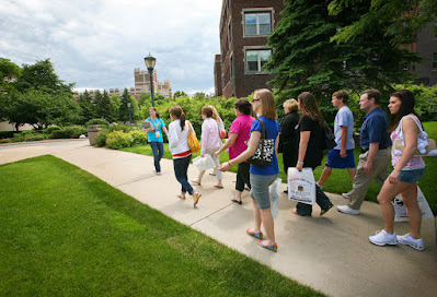 A student conducting a college tour for visitors