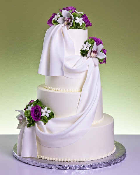 Four Tier White Wedding Cake With French Drape and Flowers