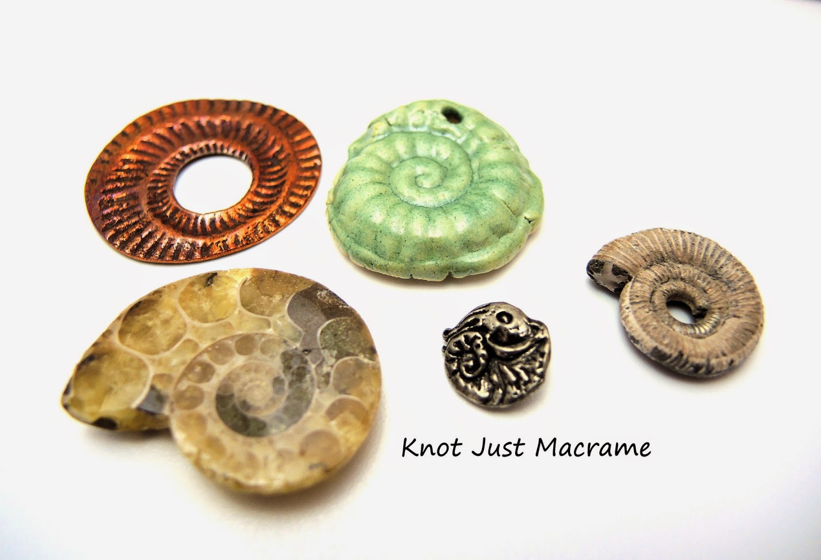 Various ammonites in copper, pewter, ceramic and fossil