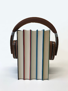 books surrounded by headphones