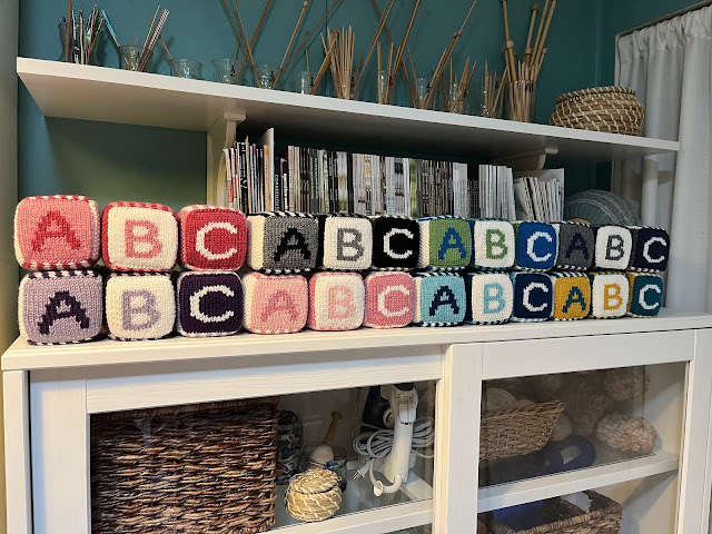 knitted abc baby blocks in many colors on a cabinet