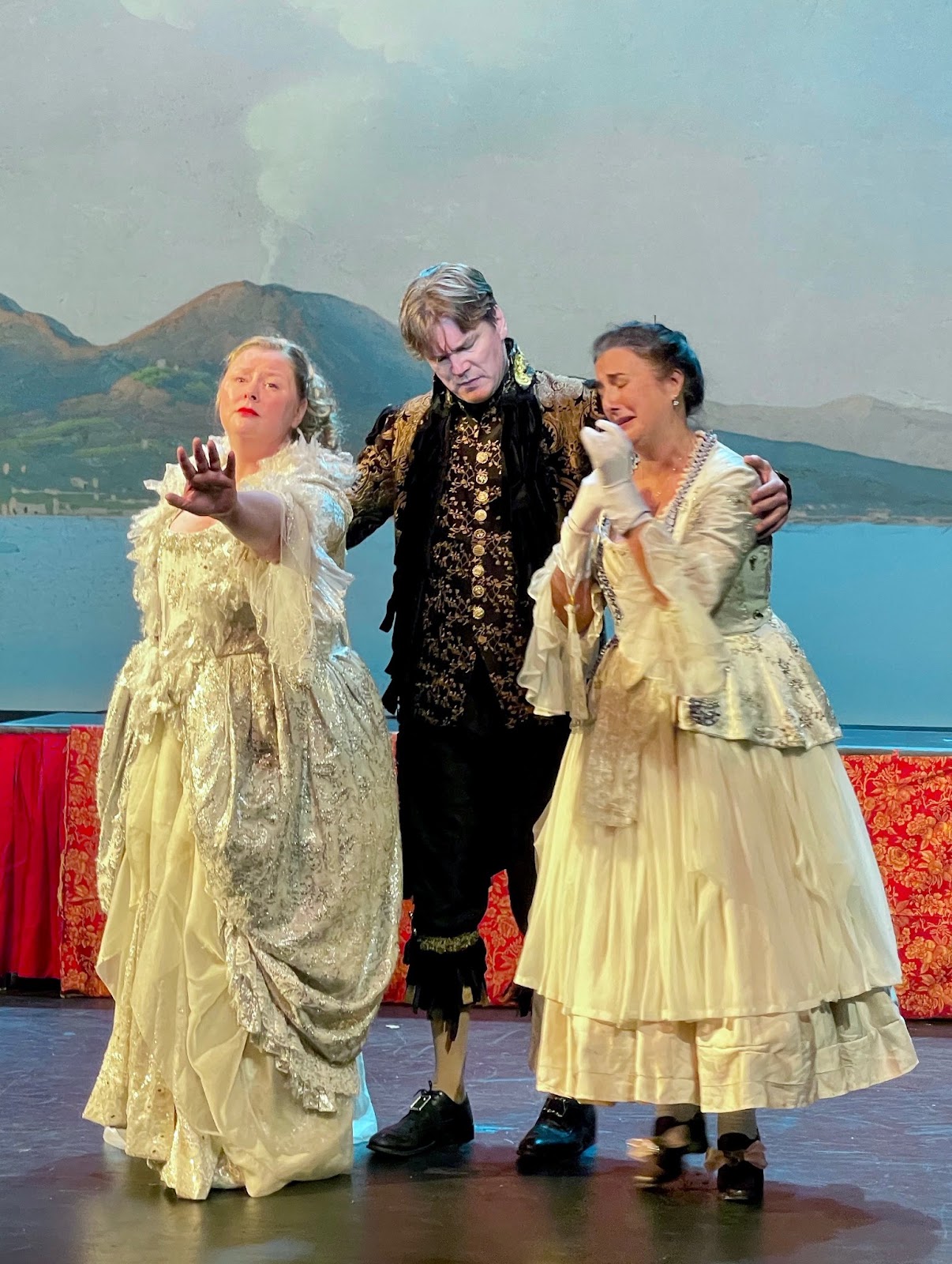 IN REVIEW: (from left to right) soprano MEREDITH HANSEN as Fiordiligi, bass DENIS SEDOV as Don Alfonso, and mezzo-soprano LISA CHAVEZ as Dorabella in Opera in Williamsburg's 2022 production of Wolfgang Amadeus Mozart's COSÌ FAN TUTTE [Photograph by Roxane Revon, © by Opera in Williamsburg]