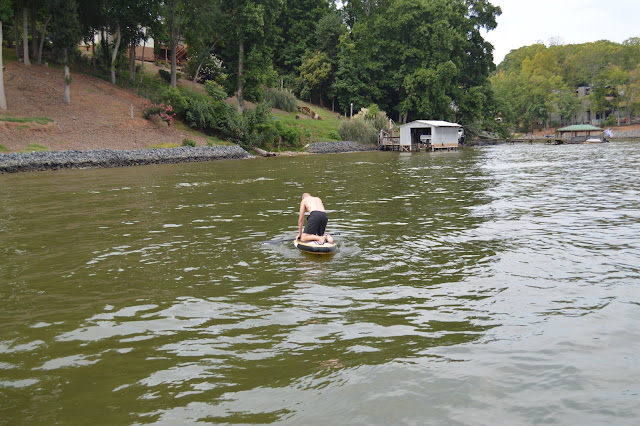 Dad trying to stand on the paddle board.