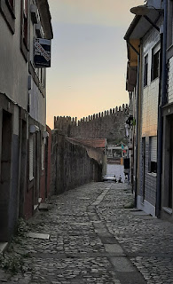 ruela e casarios do Porto com muralha medieval ao fundo