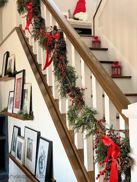 garland on stair railing with red ribbons