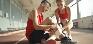 Woman applying bandage on man's leg. Aerobic