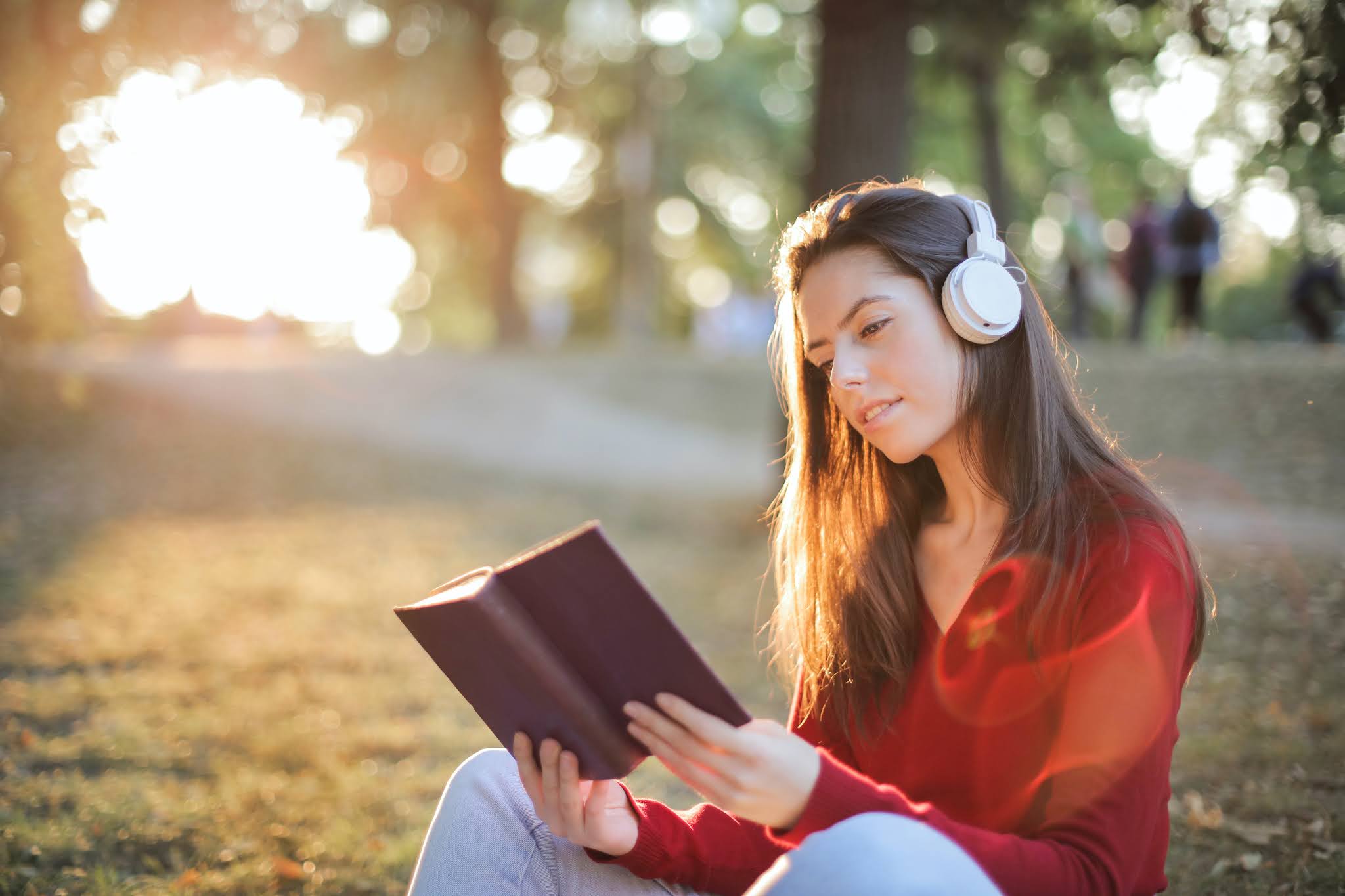 Girl wearing headphones reading a book. Photo by Andrea Piacquadio from Pexels