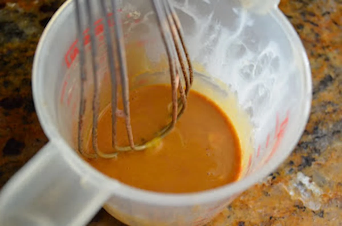 Egg yolks whisked with Chocolate Ice Cream Base in a measuring cup.