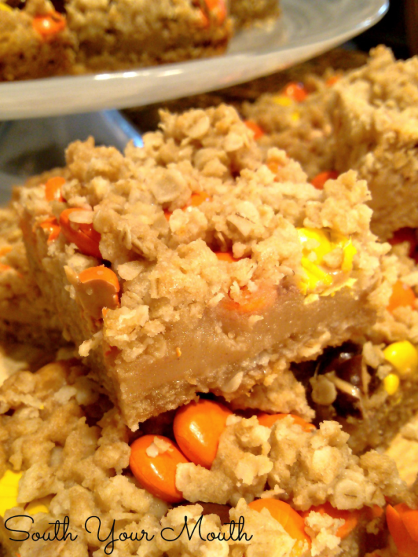 Reese’s Pieces Peanut Butter Bars! A simple recipe for oatmeal bars stuffed with peanut butter fudge topped with Reese's Pieces candies perfect for fall and Halloween!