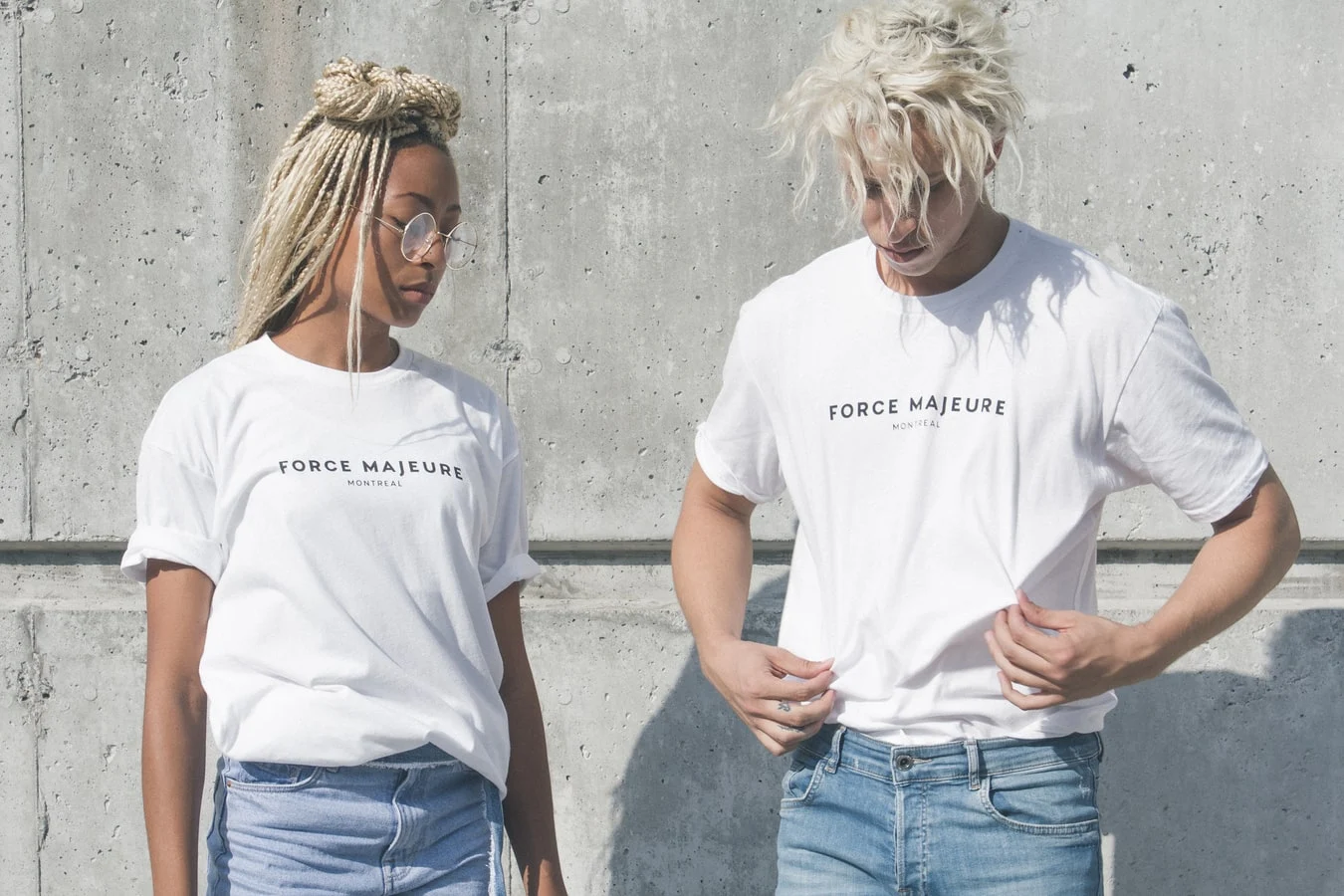 girl and boy in white tee shirts posing close to a cement wall