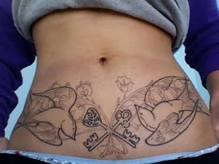 Una mujer con un tatuaje tapando sus estrias