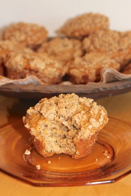 Side view of a pumpkin streusel muffin with a bite out of it.