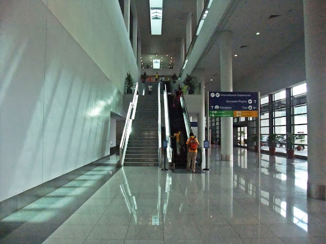 escalators at the far end of arrival lobby going up to depature checj-in hall of NAIA Terminal 3