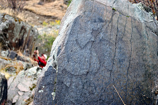 A visitor at Buffalo Eddy takes a picture of a petroglyph